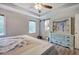 Main bedroom with barn door to bathroom, tray ceiling, and a ceiling fan at 80 Broadlands Dr, White, GA 30184