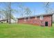 This backyard features a well-maintained lawn and brick exterior with black door at 101 Longstreet Cir, Oxford, GA 30054