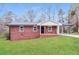 Charming brick home featuring a well-manicured lawn and covered parking area at 101 Longstreet Cir, Oxford, GA 30054