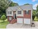 Two-story home featuring a brick and siding exterior, two-car garage, and landscaped front yard at 173 Cline Smith Ne Rd, Cartersville, GA 30121
