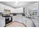 Well-lit kitchen featuring stainless steel appliances, white cabinetry, and ample counter space at 173 Cline Smith Ne Rd, Cartersville, GA 30121