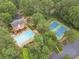 Aerial view of a community with a pool, tennis courts, and mature trees at 2056 Plantation Rd, Lawrenceville, GA 30044