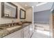 Bathroom featuring double vanity, granite countertops, and a soaking tub offers a serene and spa-like experience at 2056 Plantation Rd, Lawrenceville, GA 30044