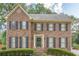 Stately brick home featuring classic shutters, a manicured lawn, and a welcoming entrance for timeless appeal at 2056 Plantation Rd, Lawrenceville, GA 30044