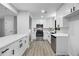 Modern kitchen features white cabinets, stainless steel appliances, gray flooring, and a sleek countertop and sink at 2246 Hightrail Ct, Lithonia, GA 30058