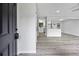 Inviting living room featuring new gray flooring that flows into the bright, white kitchen with stainless steel appliances at 2246 Hightrail Ct, Lithonia, GA 30058