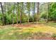 Expansive, grassy backyard with mature trees and wood fence for privacy in a serene, natural setting at 2279 Hickory Grove Nw Rd, Acworth, GA 30101