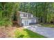 This two-story house has a spacious driveway and a well-maintained lawn, surrounded by lush greenery and trees at 630 Pennylake Ct, Stone Mountain, GA 30087