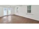 Bright living area featuring hardwood floors, dual windows with blinds, and glass doors to the exterior at 630 Pennylake Ct, Stone Mountain, GA 30087