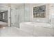 Bright bathroom features a glass-enclosed shower, garden tub, and large window for natural light at 7691 Brazos Trl, Fairburn, GA 30213