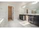 Modern bathroom with dual sinks, granite countertops, white marble floors, and a walk-in closet entrance at 7691 Brazos Trl, Fairburn, GA 30213