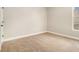 A clean and empty bedroom with neutral paint and carpet, a single window, and white trim at 7691 Brazos Trl, Fairburn, GA 30213
