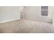 An empty bedroom with carpet, light walls, white trim, and a window for natural light at 7691 Brazos Trl, Fairburn, GA 30213