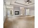 Bright bedroom with a tray ceiling, fireplace, carpet, and natural light from large windows at 7691 Brazos Trl, Fairburn, GA 30213