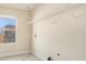 Bright laundry room with a window, shelf, and tile flooring at 7691 Brazos Trl, Fairburn, GA 30213
