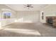 Spacious living room with carpet, a stone fireplace, and decorative wall trim at 7691 Brazos Trl, Fairburn, GA 30213