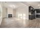 Living room with a fireplace, black appliances, and wood flooring at 7691 Brazos Trl, Fairburn, GA 30213