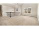Open loft area featuring neutral walls, carpeted flooring, and ample natural light from the large window at 7691 Brazos Trl, Fairburn, GA 30213