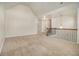 Spacious loft area with neutral walls, carpeted flooring, and staircase leading to other floors at 7691 Brazos Trl, Fairburn, GA 30213