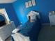 Cozy bedroom featuring bright blue walls, white furniture, and a comfortable bed at 11547 Hathaway Dr, Hampton, GA 30228