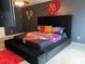 Unique bedroom showcasing a tufted platform bed with a vibrant floral comforter and a large heart decoration on the wall at 11547 Hathaway Dr, Hampton, GA 30228