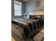 Elegant bedroom with a silver-trimmed bed, dark bedding, and a modern starburst mirror, creating a stylish retreat at 11547 Hathaway Dr, Hampton, GA 30228