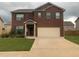 Two-story brick home boasts a well-manicured lawn and an attached two-car garage, providing ample space for parking at 11547 Hathaway Dr, Hampton, GA 30228