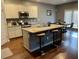 An open kitchen with a large island, stainless steel appliances, and modern lighting at 11547 Hathaway Dr, Hampton, GA 30228