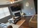 Relaxing living room featuring a fireplace, a large screen TV, comfortable seating, and hardwood floors, ideal for gatherings at 11547 Hathaway Dr, Hampton, GA 30228
