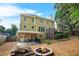 Backyard features a covered patio, fire pit, spacious lawn, and beautiful exterior of the home at 3059 Brookgreen Trl, Lawrenceville, GA 30043