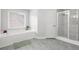 Bright bathroom with soaking tub, walk-in shower, and contemporary tile flooring at 3059 Brookgreen Trl, Lawrenceville, GA 30043