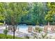 Seating and relaxing view of the community swimming pool surrounded by lounge chairs and a tree-lined perimeter at 3059 Brookgreen Trl, Lawrenceville, GA 30043