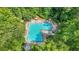 Aerial shot of the community swimming pool with ample seating and sunbathing areas surrounded by trees at 3059 Brookgreen Trl, Lawrenceville, GA 30043
