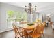 Sunlit dining room with a chandelier and wood table offers ample space for hosting and comfortable dining at 3059 Brookgreen Trl, Lawrenceville, GA 30043