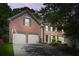 Exterior view of a beautiful brick two-story home featuring an attached two-car garage at dusk at 3059 Brookgreen Trl, Lawrenceville, GA 30043