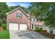 Exterior view of a beautiful brick two-story home featuring an attached two-car garage and front landscaping at 3059 Brookgreen Trl, Lawrenceville, GA 30043