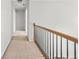 Upstairs hallway featuring neutral paint and carpet, wooden railing, and easy access to bedrooms at 3059 Brookgreen Trl, Lawrenceville, GA 30043
