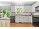 Modern kitchen with stainless steel dishwasher, granite countertops, white cabinets, and hardwood floors at 3059 Brookgreen Trl, Lawrenceville, GA 30043