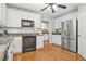 Clean kitchen featuring stainless steel refrigerator, hardwood floors, white cabinets, and black appliances at 3059 Brookgreen Trl, Lawrenceville, GA 30043