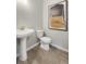 Cozy powder room showcasing a pedestal sink, elongated toilet, and neutral decor at 4317 Azalea Ridge Way, Hoschton, GA 30548