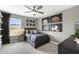 Gray accent bedroom features a ceiling fan, outside views, and artwork at 4317 Azalea Ridge Way, Hoschton, GA 30548