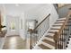 Elegant staircase with wood treads and black iron balusters, adjacent to a light-filled office space at 4317 Azalea Ridge Way, Hoschton, GA 30548