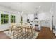 Bright dining area with stylish lighting, hardwood floors, and an adjacent modern kitchen with white cabinets at 779 Keystone Dr, Woodstock, GA 30188