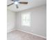 Neutral bedroom with a carpeted floor, lit ceiling fan, and window offering a serene and comfortable atmosphere at 1997 Villa Rica Hwy, Dallas, GA 30157