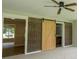 Bedroom featuring exposed brick, barn door to bathroom, ceiling fan, and great natural light at 1997 Villa Rica Hwy, Dallas, GA 30157