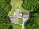 Aerial view showcasing the home's layout with a lush green canopy of trees and winding driveway at 2680 Bay Ridge Dr, Loganville, GA 30052