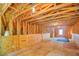 Unfinished attic with wood beams, flooring, and natural light entering from the lone window at 2680 Bay Ridge Dr, Loganville, GA 30052