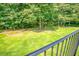 View from a balcony overlooking a lush green backyard with mature trees at 2680 Bay Ridge Dr, Loganville, GA 30052
