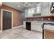 Well-lit basement kitchen features white cabinets, modern appliances, and tile flooring at 2680 Bay Ridge Dr, Loganville, GA 30052