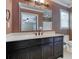 Bathroom featuring a single sink vanity with a framed mirror and a view into the bedroom at 2680 Bay Ridge Dr, Loganville, GA 30052